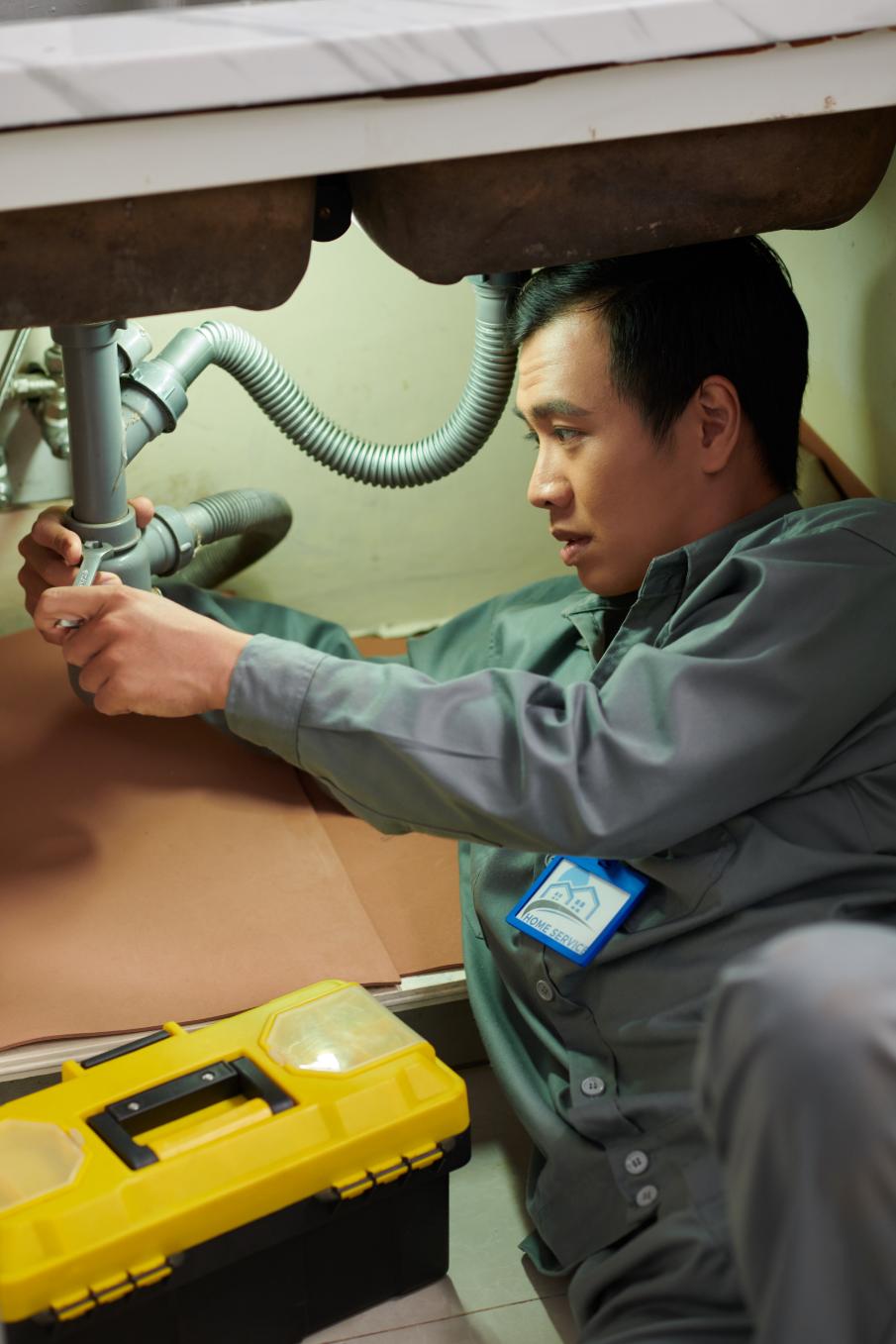 Skilled plumber working on water heater connections